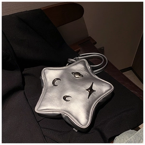 Detail view of silver star-shaped crossbody bag with metallic moon and planet charms