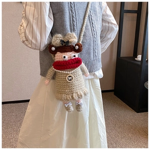 Détail du sac à bandoulière au crochet fait main avec collier de perles et lèvres rouges