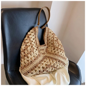 Detailed macro shot of the hollow diamond pattern on the woven straw hobo bag surface
