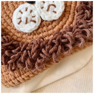 Vue macro de la texture du tricot au crochet et des détails de broderie en laine brune