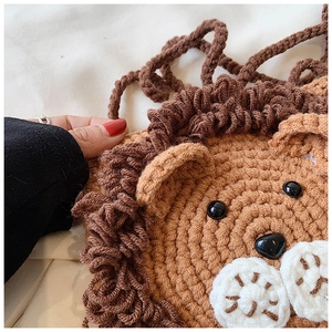 Gros plan sur un sac lion au crochet montrant la texture de la maille et les détails