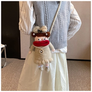 Détail du sac bandoulière au crochet fait main avec visage de poupée et collier de perles
