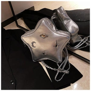 Star-shaped silver crossbody bag detail with metallic texture and planet charms on black blazer