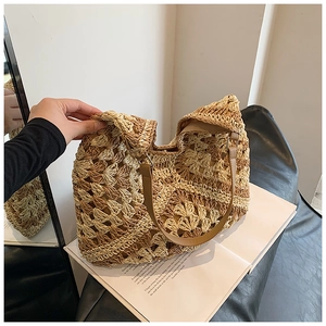 Detail of hand-woven crochet tote bag featuring contrast colors and brown leather handle