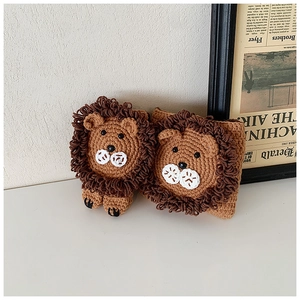 Détail de deux charms lion au crochet faits main avec texture de tricot marron fine