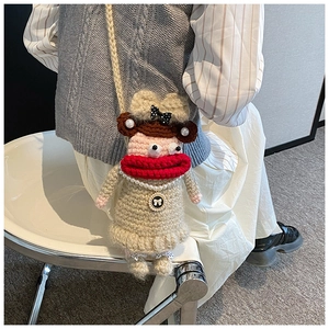 Détail du sac à bandoulière au crochet avec de grandes lèvres rouges et collier de perles
