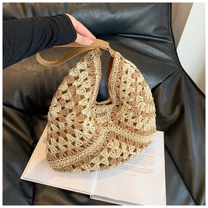 Detail of hand-woven straw bag featuring beige and dark brown wavy pattern with leather handle
