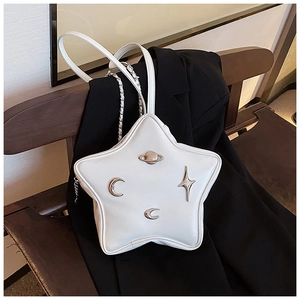 Detail view of white star-shaped shoulder bag with metallic moon and planet ornaments