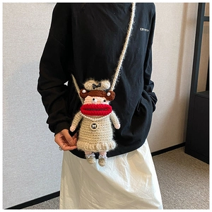 Détail du sac bandoulière au crochet avec de grandes lèvres rouges et collier de perles