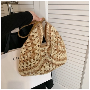 Detail of hand-woven straw tote with bicolor wavy texture and durable leather handles