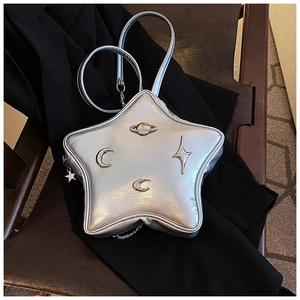 Detailed macro of silver star-shaped bag with saturn planet and moon metallic hardware