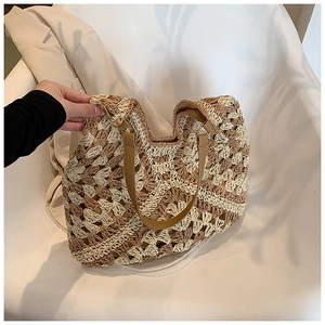 Close-up of bohemian crochet straw tote featuring brown faux leather handles and metal rings
