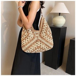 Detail of hand-crocheted hobo bag showing beige and tan knit texture with leather strap