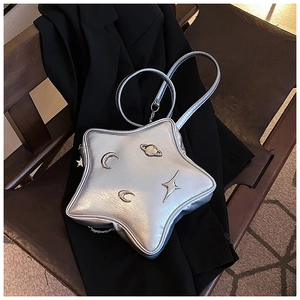 Silver metallic star-shaped crossbody bag with moon and planet charms on black fabric