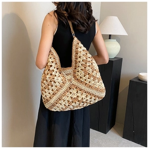 Detail of handmade knit hobo bag with geometric hollow patterns and durable metal rings