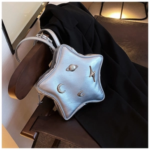 Silver star-shaped crossbody bag with metallic moon and planet charms on black suit