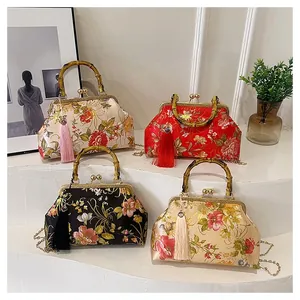 Four vintage satin evening bags with bamboo handles and floral patterns on display