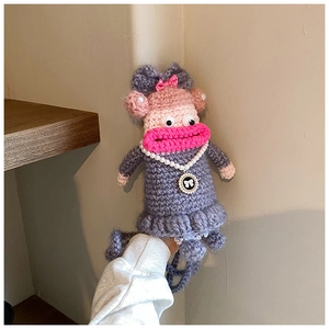Détail d'un sac de téléphone au crochet fait main avec poupée grise et grosses lèvres