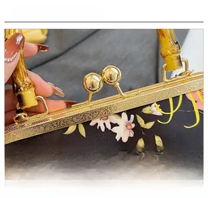 Detail of floral fabric handbag with vintage gold metal clasp and bamboo handle