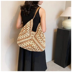 Detail of a large hand-woven crochet shoulder bag with contrast patterns and leather strap