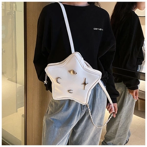 Close-up of star-shaped white leather crossbody bag with silver metallic cosmic charms