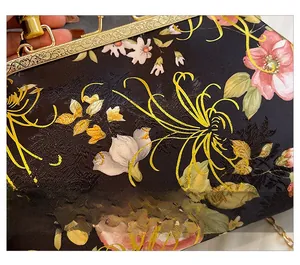 Macro shot of floral jacquard fabric and vintage bamboo handle on a silk handbag