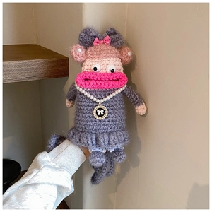 Détail d'un sac poupée crocheté à la main avec de grosses lèvres roses et collier de perles