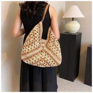 Macro shot of gradient crochet hobo bag with wave patterns and leather strap detail