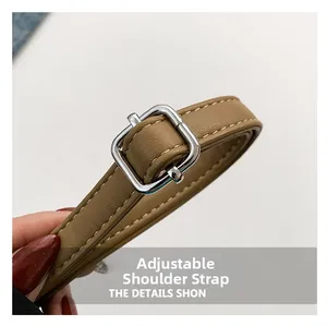 Close-up of adjustable brown leather shoulder strap with silver buckle and fine stitching