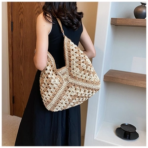 Detailed close-up of a large bohemian straw tote bag with intricate hollow crochet patterns