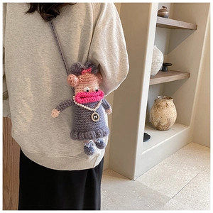 Gros plan d'un sac bandoulière au crochet fait main avec collier de perles et visage drôle