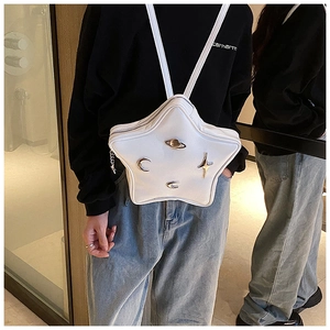 Detail of white star-shaped backpack with silver celestial charms and metallic hardware