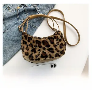 Detail of leopard print plush crescent bag with brown adjustable leather shoulder strap