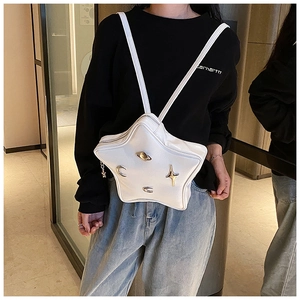 Star-shaped white leather bag shown on a model, featuring metallic moon and saturn charms