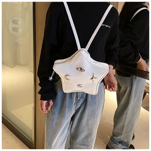Close-up of star-shaped white PU leather backpack with metallic space-themed charms
