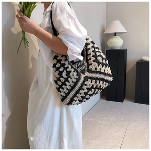 Detailed shot of handmade woven shoulder bag with black and white geometric crochet texture