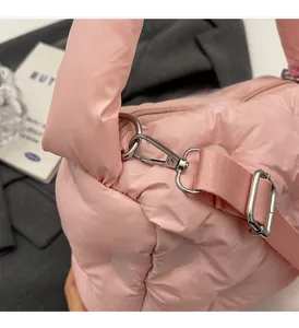 Detail of pink quilted puffer bag showing silver hardware and adjustable strap attachment