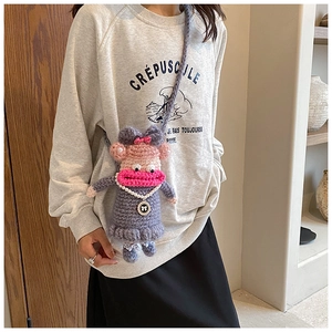 Détail d'un sac téléphone en crochet fait main avec visage de singe 3D et perles