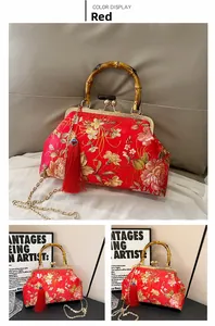 Close-up of red floral embroidery on satin bag with bamboo handle and silk tassel detail