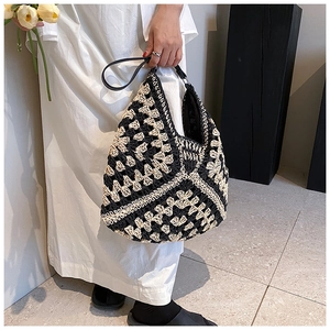 Detail of bohemian crochet hobo bag with contrast geometric pattern and leather strap