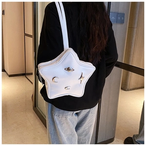 Detail of star-shaped crossbody bag with celestial metallic charms and chain strap