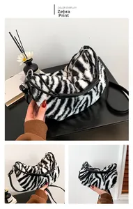 Detailed view of plush zebra print shoulder bag with black leather straps and crescent shape