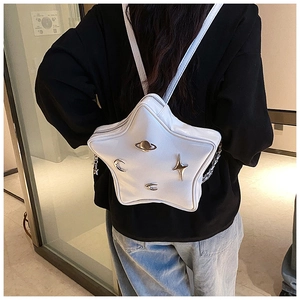 Detail of white star-shaped backpack with cosmic metal charms and side chain decor
