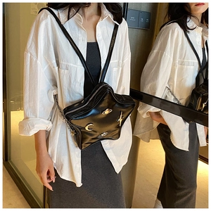Detailed view of black star-shaped crossbody bag with gold moon and saturn charms