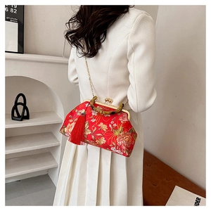 Détail du sac qipao en soie rouge avec broderie de pivoines et poignée en bambou