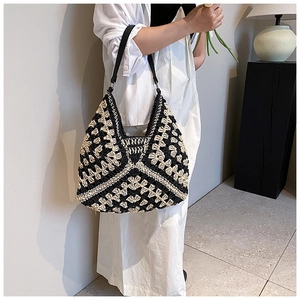 Detail of handmade crochet shoulder bag with black and beige geometric woven textures