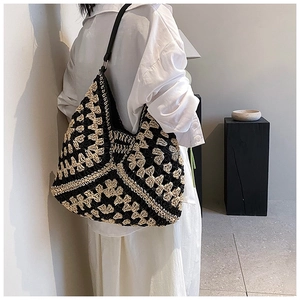 Detail of bohemian handmade crochet tote bag featuring black and beige geometric patterns