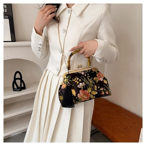 Detail of vintage floral silk handbag with bamboo handle and elegant black tassel