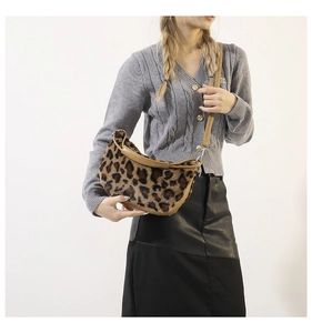 Detailed view of plush leopard print crossbody bag with sleek brown leather trim and strap