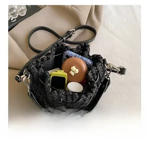 Internal capacity of the black woven bucket bag showing phone and cosmetics items